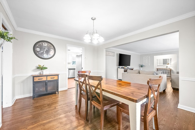 dining area featuring hardwood / wood-style flooring, an inviting chandelier, and crown molding