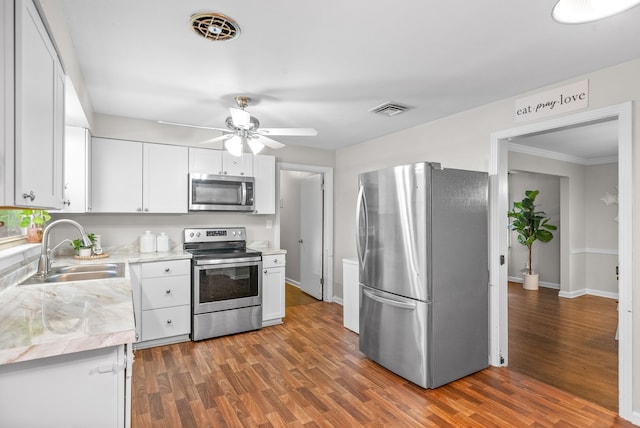 kitchen with white cabinets, stainless steel appliances, sink, and dark hardwood / wood-style flooring