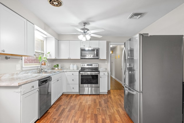 kitchen with white cabinetry, stainless steel appliances, sink, and dark hardwood / wood-style flooring