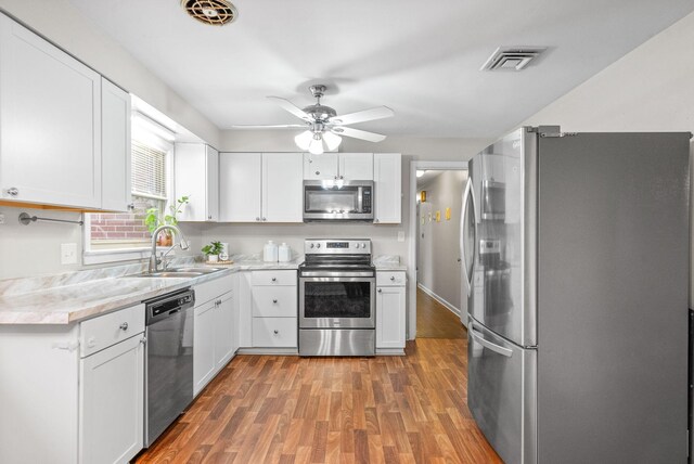 3 Hillwood Ct, Clarksville, TN 37043 - kitchen with appliances with stainless steel finishes, a sink, light wood-type flooring, light countertops, and white cabinetry