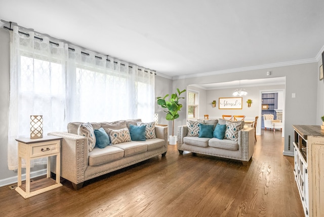 living room featuring crown molding, dark hardwood / wood-style flooring, and a notable chandelier