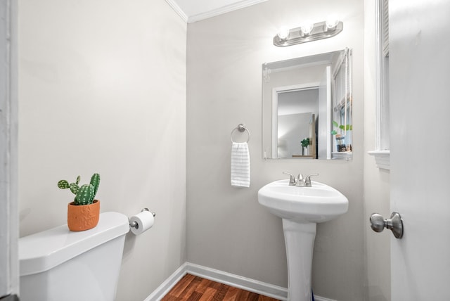 bathroom with sink, hardwood / wood-style flooring, toilet, and crown molding