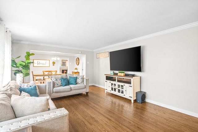 living room with ornamental molding, dark wood-type flooring, and an inviting chandelier