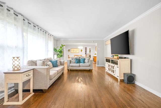 living room with an inviting chandelier, hardwood / wood-style flooring, and ornamental molding