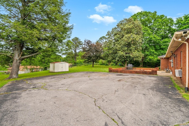 3 Hillwood Ct, Clarksville, TN 37043 - view of patio featuring a storage shed, an outdoor structure, driveway, and view of scattered trees
