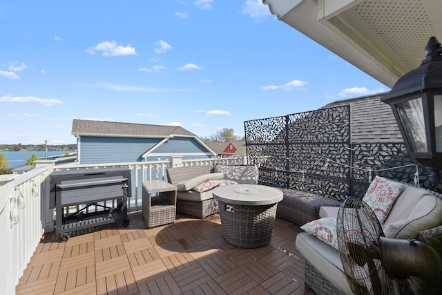 wooden deck with outdoor lounge area and a water view