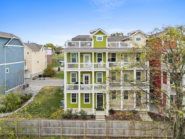 view of front of house featuring central AC unit and a balcony