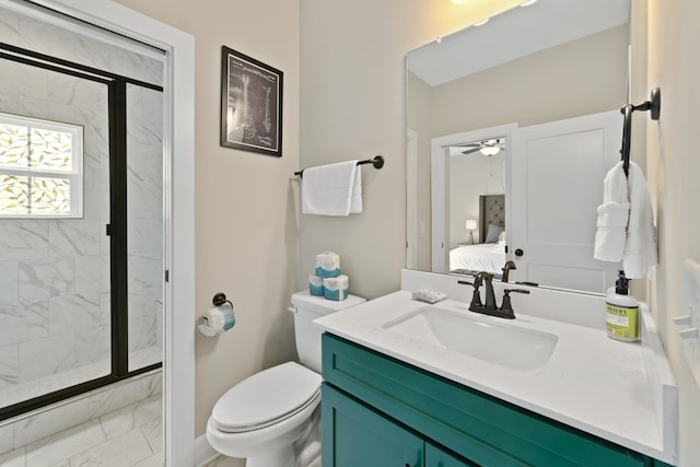 bathroom featuring toilet, vanity, a shower with door, and ceiling fan