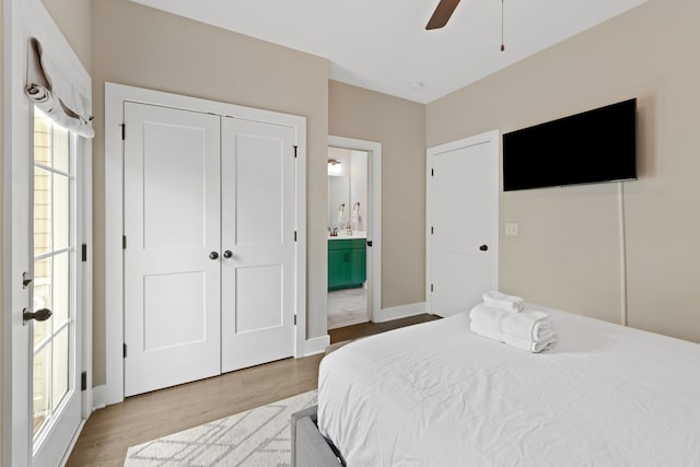 bedroom with hardwood / wood-style floors, ceiling fan, ensuite bath, and a closet