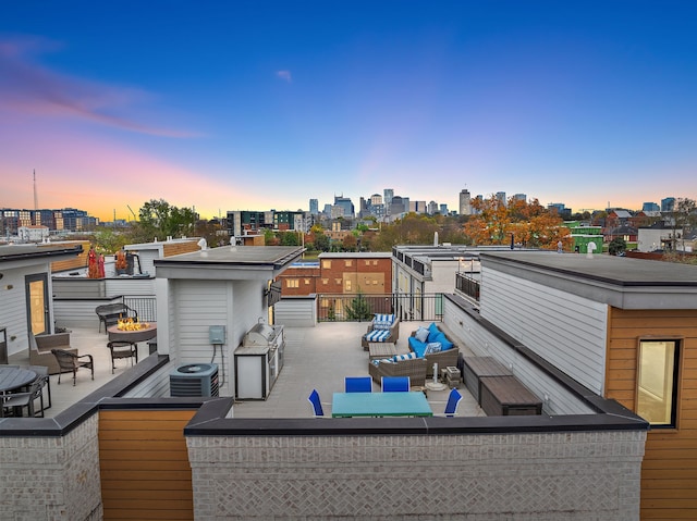 back house at dusk with outdoor lounge area, central AC, and a balcony