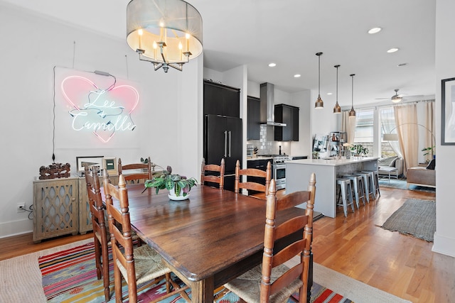 dining room featuring hardwood / wood-style floors and ceiling fan with notable chandelier