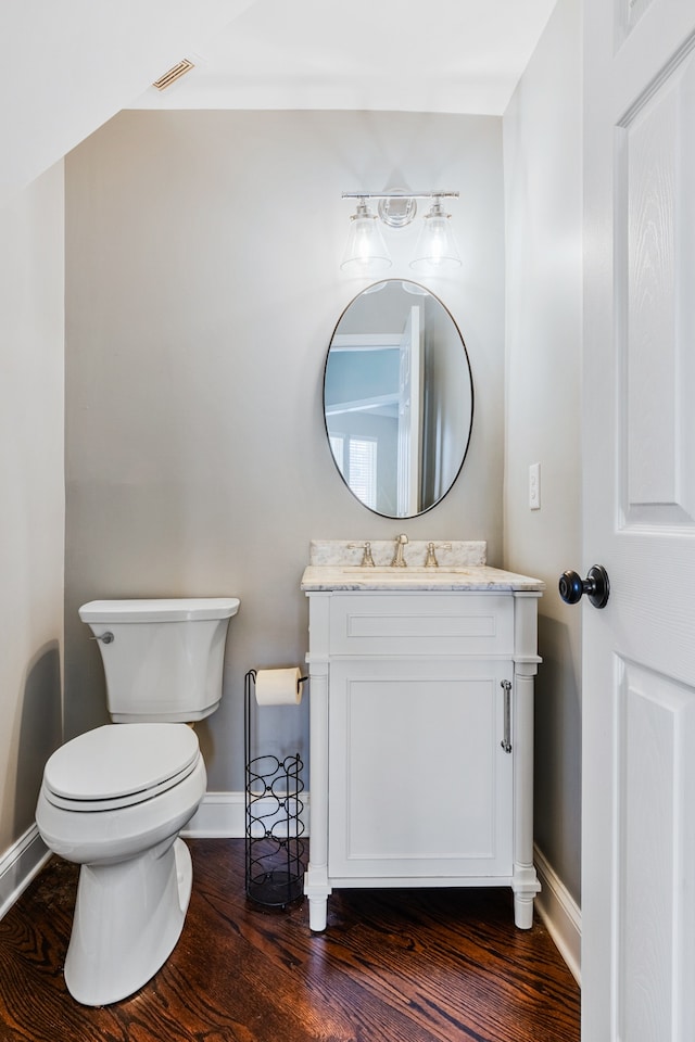 bathroom with wood-type flooring, vanity, and toilet