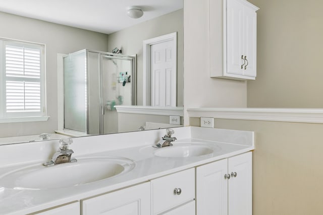 bathroom featuring vanity and a shower with door