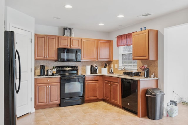 kitchen featuring tasteful backsplash, sink, light tile patterned floors, and black appliances