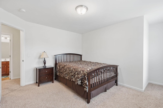 bedroom featuring light colored carpet and connected bathroom