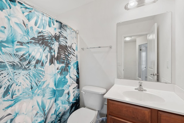 bathroom featuring vanity, toilet, and curtained shower