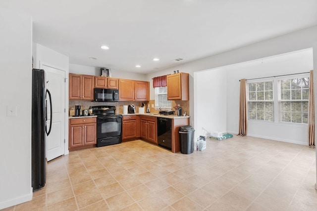 kitchen with black appliances, sink, and backsplash