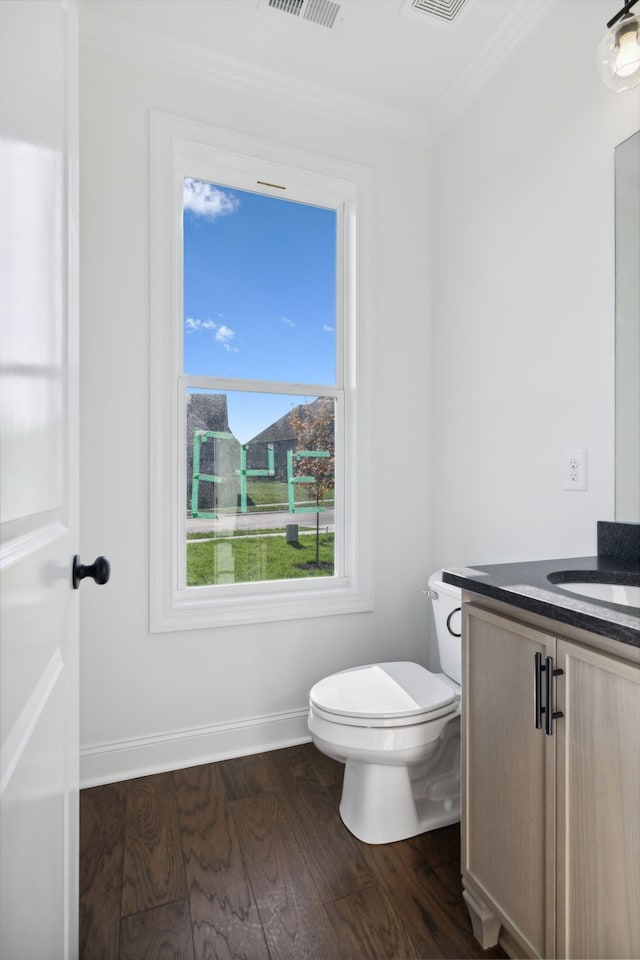 bathroom featuring ornamental molding, wood-type flooring, toilet, and vanity