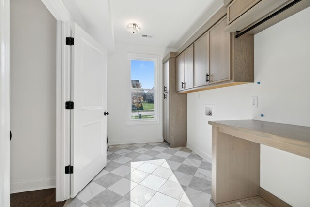 clothes washing area with cabinets and hookup for a washing machine