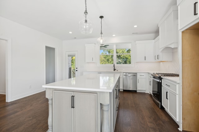 kitchen featuring stainless steel appliances, dark hardwood / wood-style flooring, white cabinetry, and a kitchen island