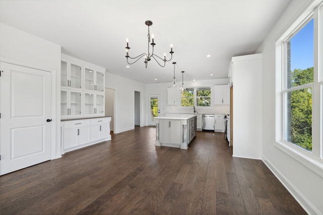 kitchen with dishwasher, a kitchen island, a wealth of natural light, and white cabinets