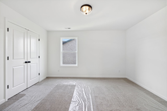 unfurnished bedroom with a closet and light carpet