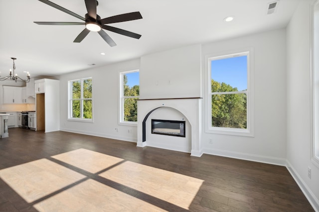 unfurnished living room with dark wood-type flooring and ceiling fan with notable chandelier