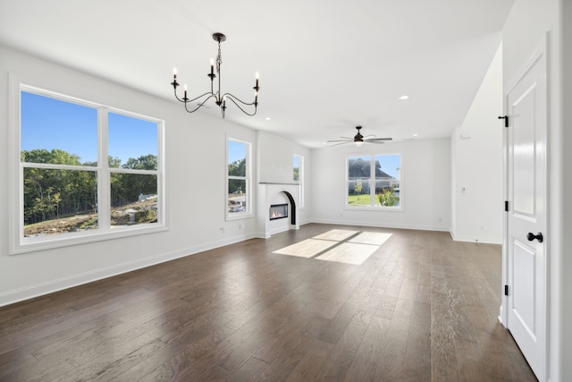 unfurnished living room with dark wood-type flooring and ceiling fan with notable chandelier