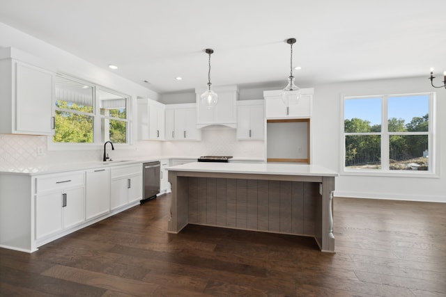 kitchen featuring a wealth of natural light, dark hardwood / wood-style floors, white cabinetry, and a center island