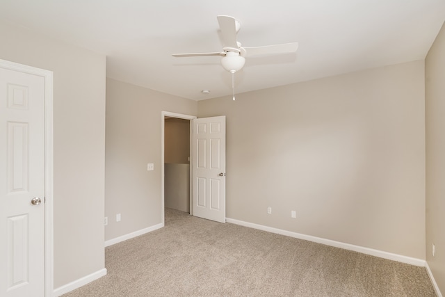 spare room featuring light colored carpet and ceiling fan