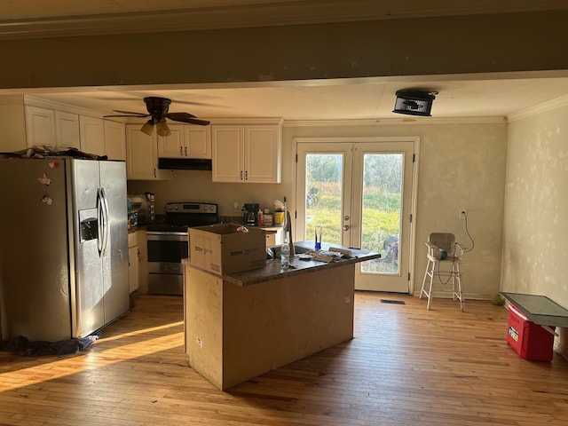 kitchen featuring ornamental molding, appliances with stainless steel finishes, light hardwood / wood-style floors, white cabinets, and ceiling fan