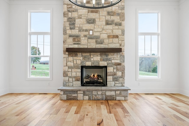 unfurnished living room with a fireplace, light wood-type flooring, and ornamental molding