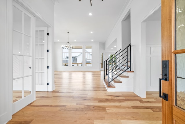 interior space featuring light hardwood / wood-style floors, a chandelier, and crown molding