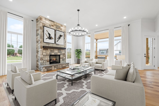 living room with ornamental molding, light wood-type flooring, and a healthy amount of sunlight