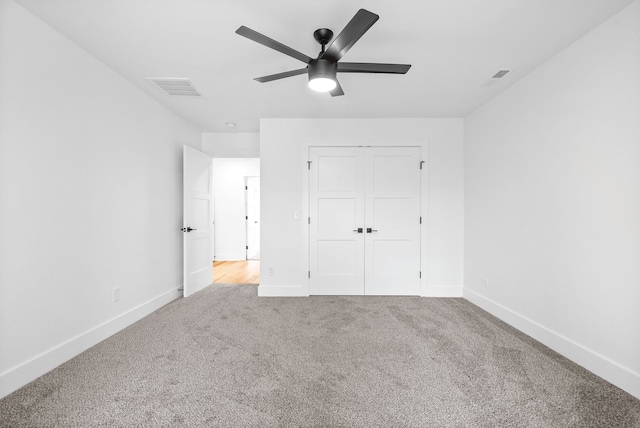 unfurnished bedroom featuring ceiling fan, light carpet, and a closet