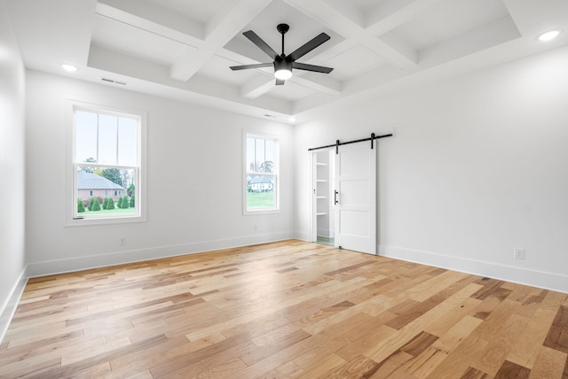 unfurnished room featuring light hardwood / wood-style floors, a barn door, coffered ceiling, ceiling fan, and beam ceiling