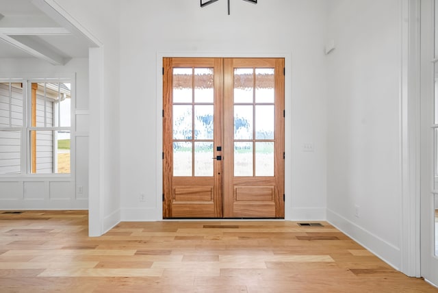 entryway with french doors and light hardwood / wood-style flooring