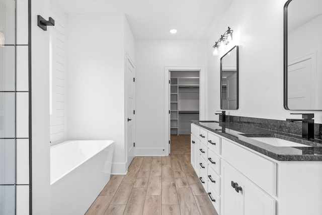 bathroom with a bath, hardwood / wood-style flooring, and vanity