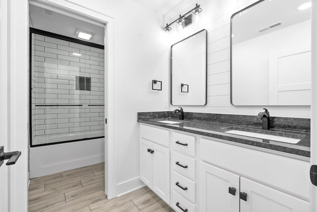 bathroom featuring combined bath / shower with glass door and vanity