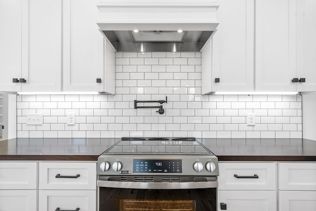 kitchen with white cabinetry, wall chimney exhaust hood, and stainless steel electric range oven