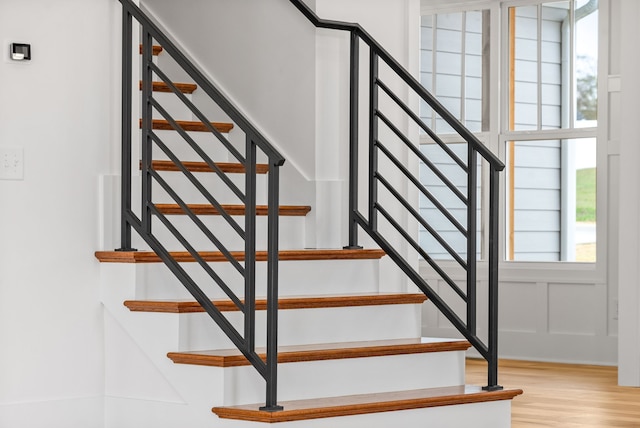 stairs featuring hardwood / wood-style floors and a healthy amount of sunlight