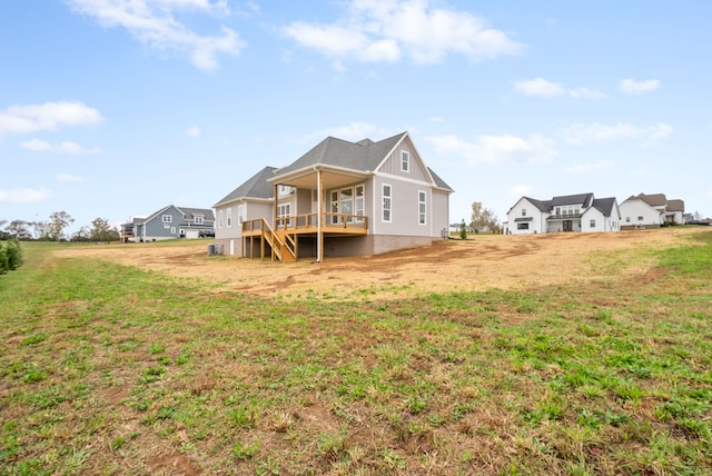 rear view of house with a wooden deck and a yard