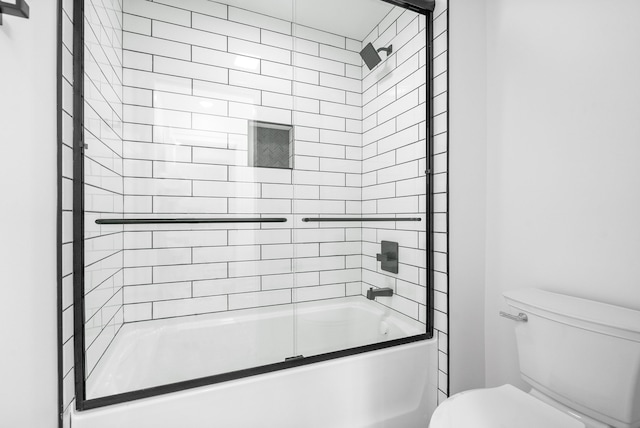 bathroom featuring bath / shower combo with glass door and toilet