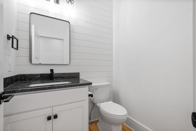 bathroom with toilet, vanity, and hardwood / wood-style floors