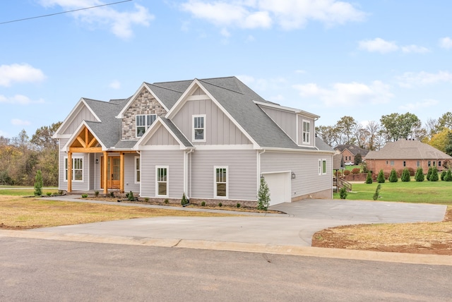 craftsman inspired home featuring a garage and a front lawn