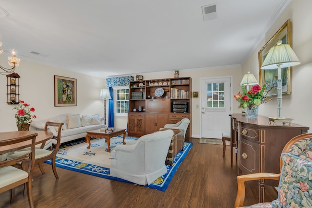 living room featuring dark wood-type flooring, crown molding, and a notable chandelier