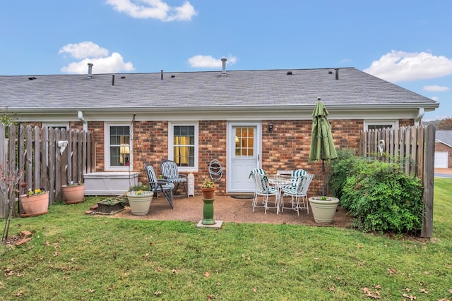 rear view of property featuring a lawn and a patio