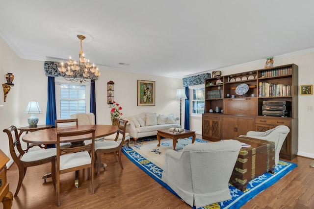 living room with a chandelier, wood-type flooring, and ornamental molding