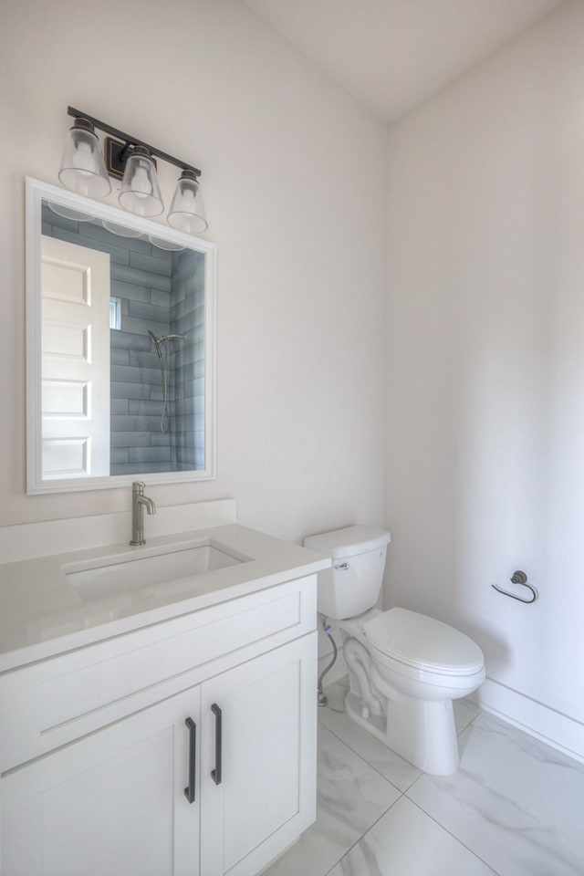 bathroom featuring vanity, toilet, and a tile shower