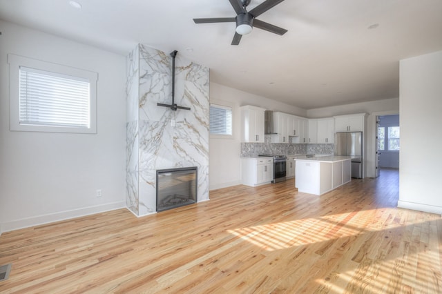 unfurnished living room featuring light wood-type flooring, a healthy amount of sunlight, and sink